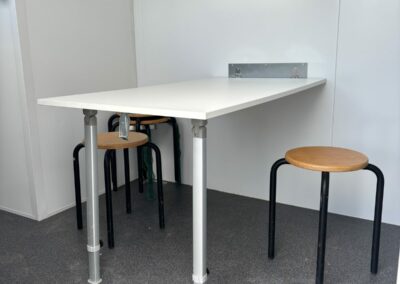 Coin réfectoire de la roulotte de chantier Equiloc avec table rabattable et tabourets